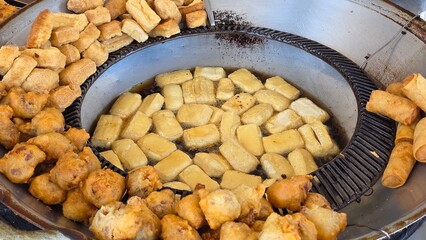 Golden crispy tofu frying in bubbling hot oil
