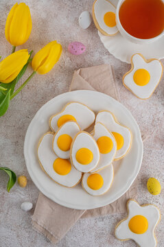 Naklejki Easter cookies in the form of fried eggs with sugar glaze on a stone background. Funny food idea for kids. Top view, copy space.