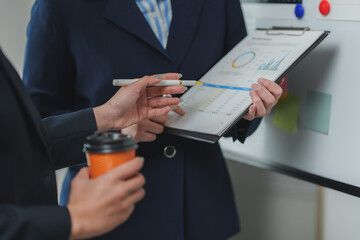 Businesswomen analyzing financial charts and reports in office meeting