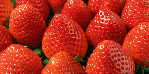 Fresh ripe strawberries in close-up. Bright red berries with green leaves create an appetizing and...