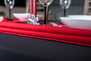 Close-up of a red napkin on black tablecloth with table setting