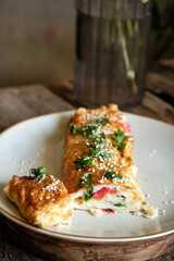 Omelette roll with cheese, tomatoes, parsley, sesame and green onions
