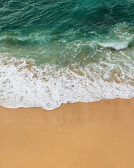 Crystal-clear water and foamy waves blend harmoniously on the shoreline, highlighting the beauty of unspoiled nature.