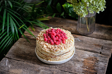 Napoleon cake with raspberry on a wooden background. Side view.