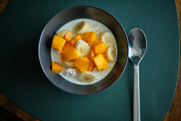 Cottage cheese with cream, banana and mango. Top view