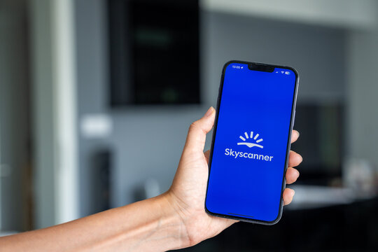 Prague, Czech republic - May 2, 2024: Woman holding iPhone with logo of application Skyscanner on the screen, using mobile application 