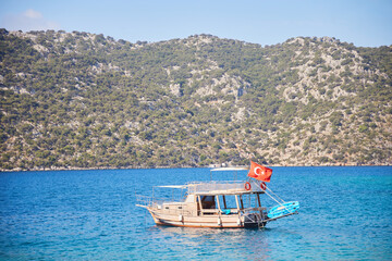 A boat with a Turkish flag on the background of Kekova Island, Turkey