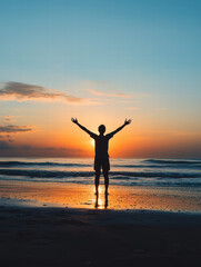 Fototapeta premium Embracing the Sunrise: Silhouette of a person standing on the shore with open arms, facing the radiant sunrise, symbolizing freedom, hope, and new beginnings.