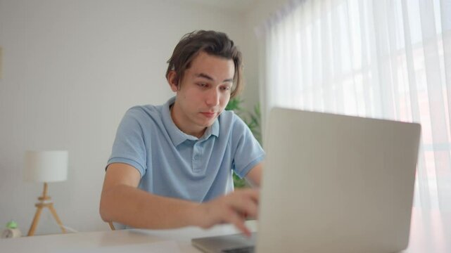 Asian young man experiencing dry eyes and fatigue while working in house. 
