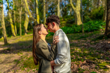 Fototapeta premium Young couple sharing a tender moment in a lush forest