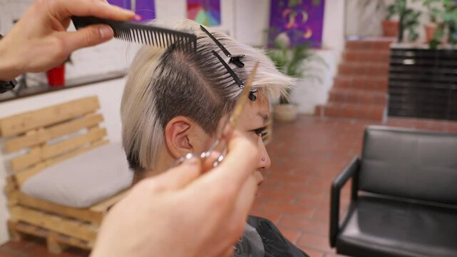 Hair stylist perfecting edgy short hairstyle in slow motion