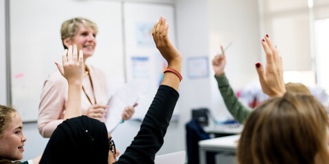 Engaged students raising hands classroom