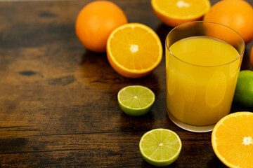 A healthy smoothie in glass with oranges and lime.Glass of orange juice, oranges