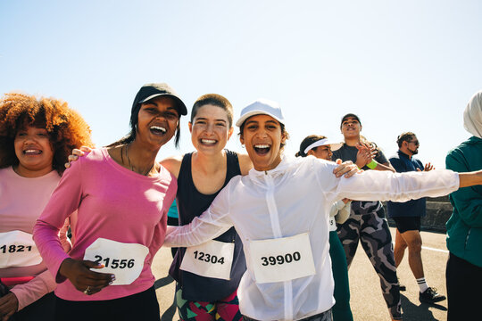 Diverse group of happy runners celebrating on race day - Powered by Adobe