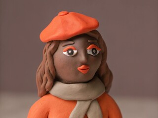 Plasticine Parisienne: French girl Insta avatar with brown clay hair in pastel tones, scarf and beret.