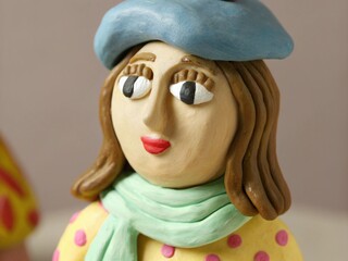Plasticine Parisienne: French girl Insta avatar with brown clay hair in pastel tones, scarf and beret.