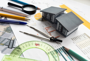 Architects house model with measurement tool and blueprints on architect desk. A architects home model with plan and blueprints. Business, architecture, building and construction concept.