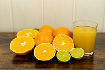 A healthy smoothie in glass with oranges and lime.Glass of orange juice, oranges