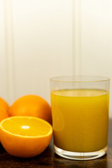 A healthy smoothie in glass with oranges and lime.Glass of orange juice, oranges