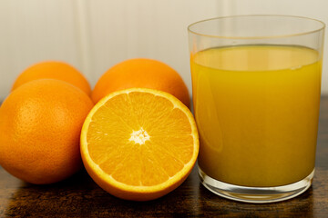 A healthy smoothie in glass with oranges and lime.Glass of orange juice, oranges