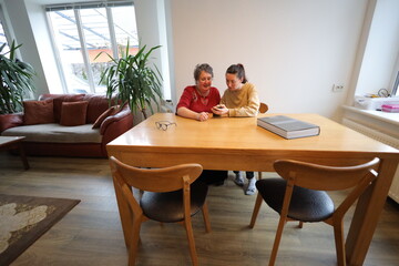 Woman showing grandmother how to use a phone  