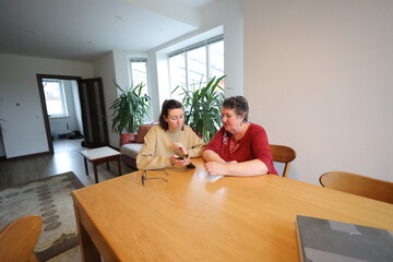 Obraz premium Woman showing grandmother how to use a phone 