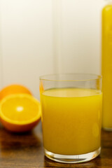 A healthy smoothie in glass with oranges and lime.Glass of orange juice, oranges