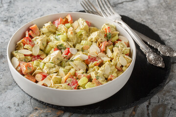 Italian pesto salad with chicken breast, vegetables and nuts close-up in a plate on the table. Horizontal