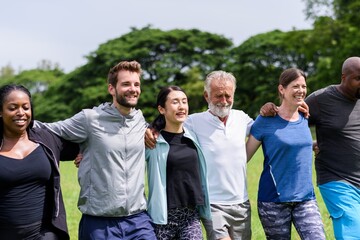 Diverse group of people outdoors, smiling and embracing. Multiracial friends enjoying nature,...