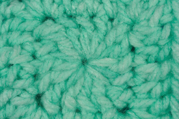 A close-up shot of a mint green crocheted circle, displaying its textured surface and handmade detail