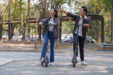 Fototapeta premium Students riding electric scooters in university campus park