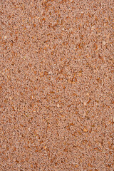 A close-up shot displays a dense pile of psyllium seeds, their oval shapes and varied brown hues creating a textured, natural pattern