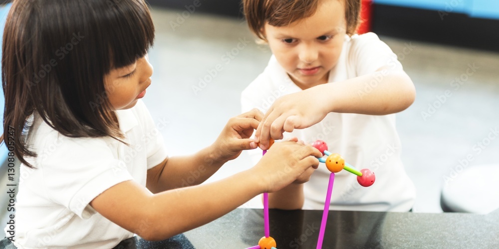 Poster Two elementary students playing with colorful construction toys at a table. Diverse children focusing on building and teamwork. Two elementary students are engaged and learning through play.