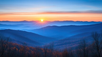 A beautiful sunrise illuminates layered mountain ranges at dawn