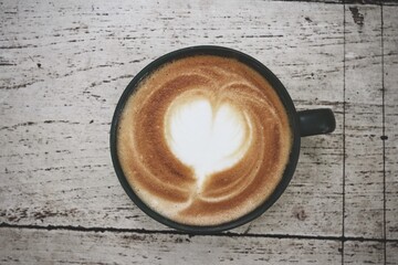 Latte art coffee cup on wooden table