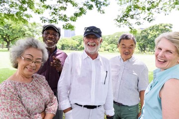 Diverse group of senior friends smiling and enjoy outdoors. Happy seniors enjoying nature in the park. Diverse group of senior men and women smiling at park. Happy diverse old people enjoy outdoor