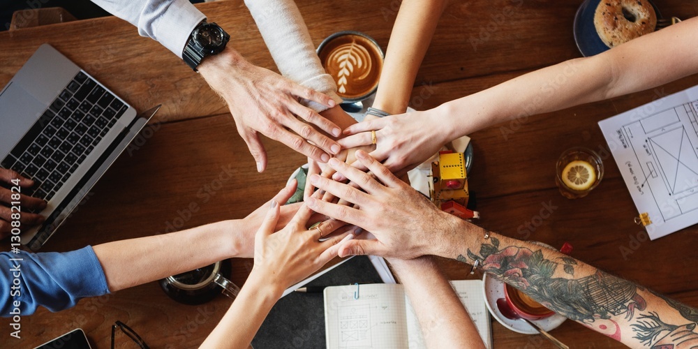 Aufkleber diverse group of hands joining together over wooden table with coffee and documents, symbolizing tea