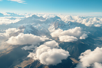 Fototapeta premium Towering peaks covered in snow, surrounded by soft white clouds, showcasing the untouched beauty of high-altitude landscapes. 