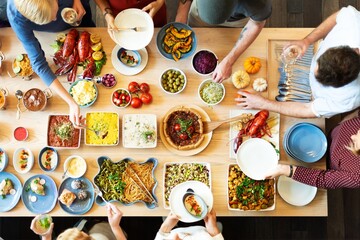 Top view of diverse people enjoy buffet with dishes like pasta, salads, and seafood. People enjoy eating buffet dishes, sharing a communal dining experience. Diverse people enjoy food at buffet table