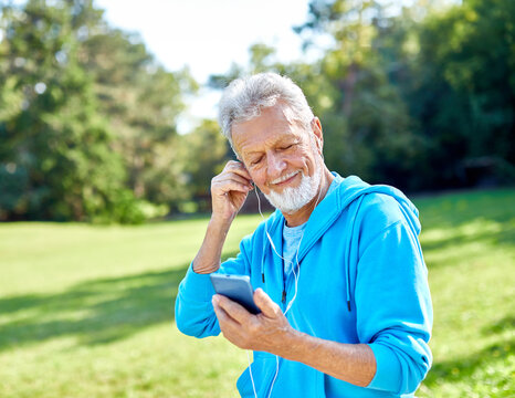 man outdoor senior  elderly phone fitness mobile smartphone music earphone app communication active fun old nature using internet connection smart phone mature retirement listen headphone training - Powered by Adobe