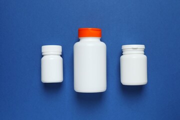White bottles on blue background, top view