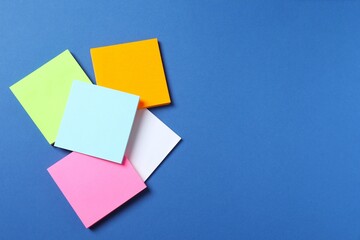 Multicolored paper stickers on a blue background