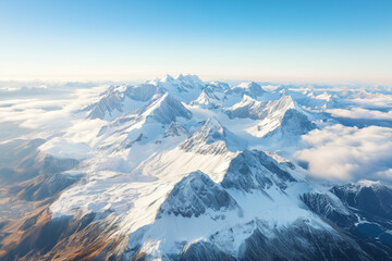 Naklejka premium Aerial view of a dramatic snowy mountain range, showcasing rugged terrain and pristine white slopes.