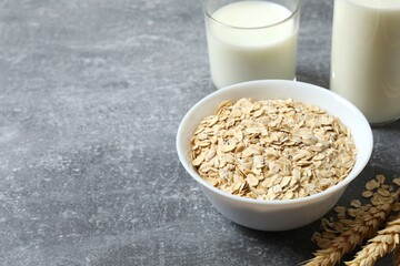 Composition with oatmeal flakes on gray background. Cooking breakfast