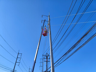 Men in work clothes and hard hats are installing high-voltage wires on a power pole
