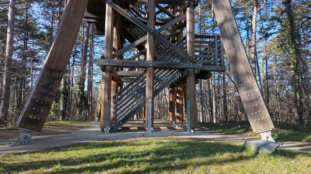 Tilt up shot of the wooden Sorhazdombi Lookout with the surrounding forest on a sunny day in Sopron, Hungary.