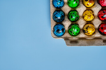 easter beautiful decorated orthodox religious quail eggs lie on egg carton on blue background with space for text