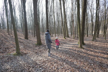 Fototapeta premium Woman and a kid walking in the forest