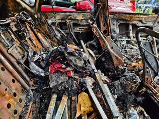 Charred remnants of a vehicle interior left behind after a devastating fire incident