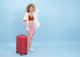 Young woman with a suitcase enjoying a sunny day, dressed stylishly in a casual outfit ready for...